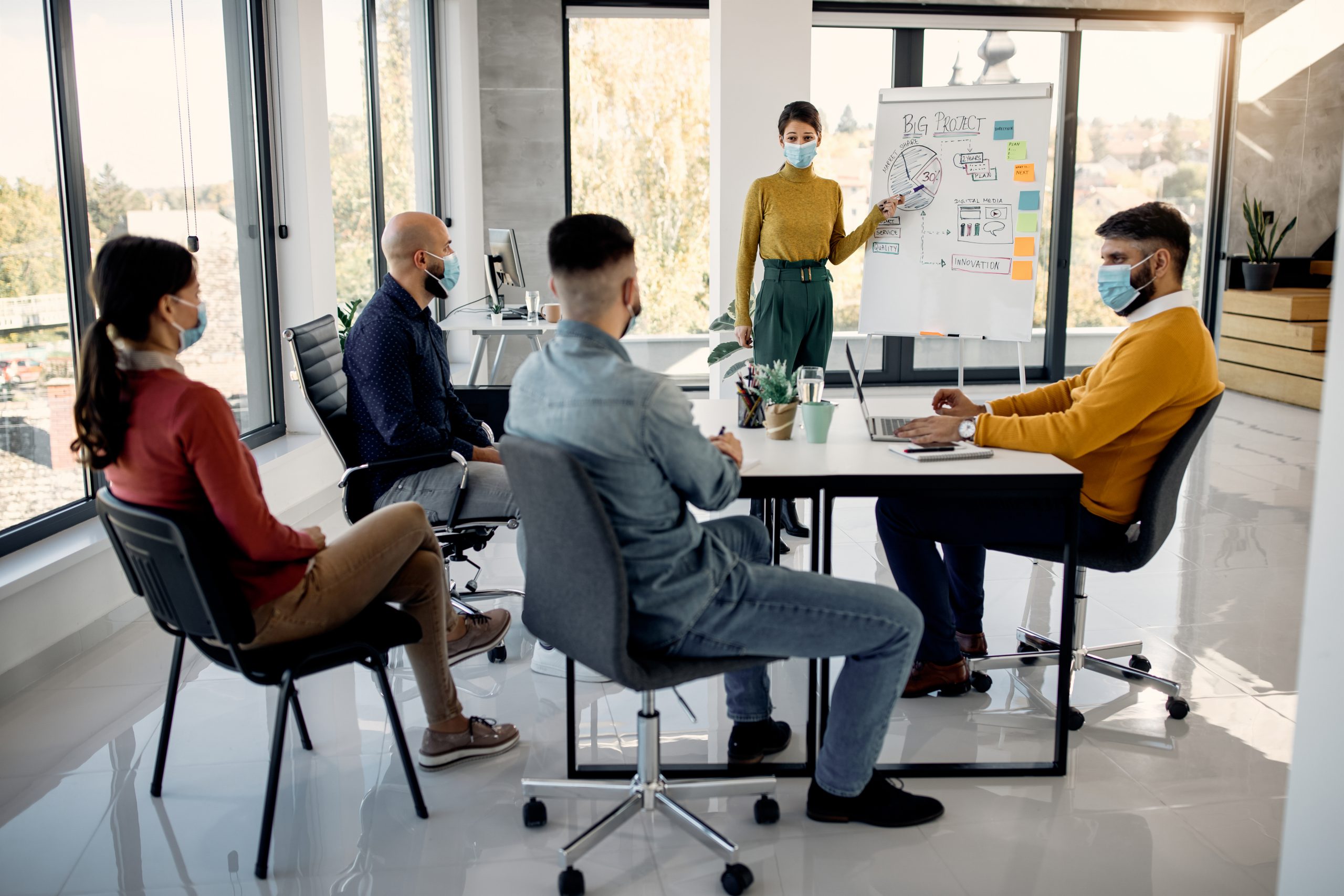 Businesswoman presenting new strategy plans on whiteboard to her